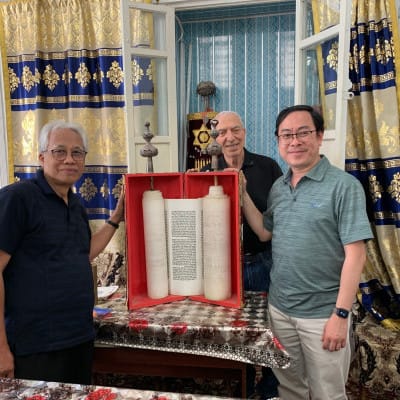 The head of Bukhara's Jewish community, which is one of the oldest continuous Jewish communities in Central Asia, hosted a visit from IGE's international delegation. Pictured are Indonesian members of IGE's delegation with the Jewish community's most treasured possession: a 1,000-year-old Torah scroll.