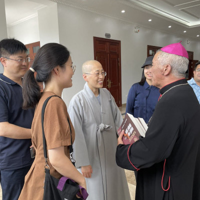 One of the training program presenters, a Buddhist monk from South Korea, talks with Vietnamese Catholic Bishop Alphonse Huu Long Nguyên.